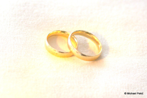 Zwei goldene Ringe auf weissen Kissen